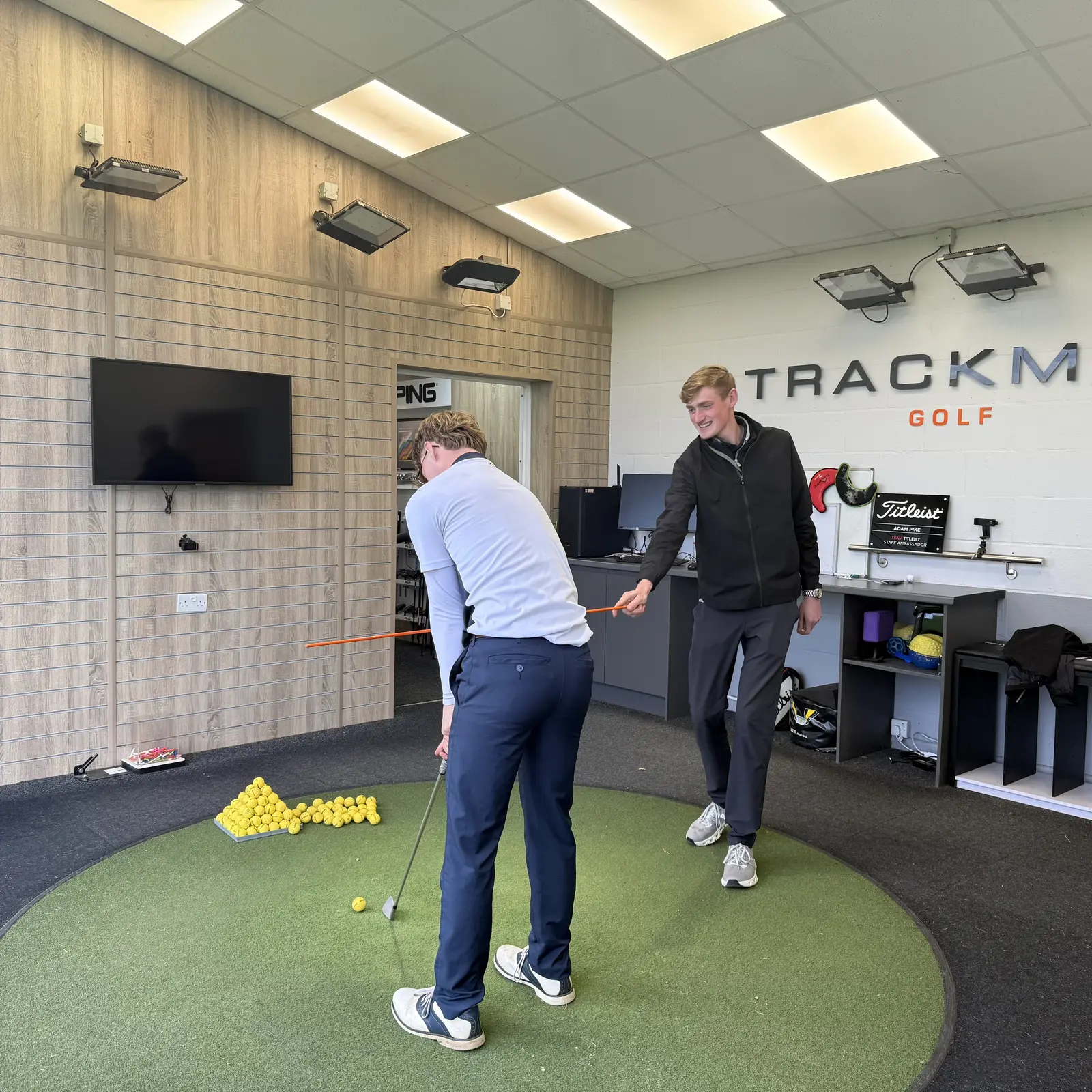 PGA coach watching a golfer swing in the Trackman swing studio at Brampton Park